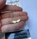 A stainless steel necklace with a winged design, displayed on a tag with an illustration of Hermes, the Greek God of commerce, wealth, and communication.
